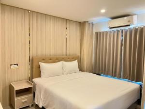 a bedroom with a white bed and a window at DF Hotel Pattaya in Pattaya South +53 photos