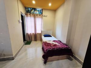 a bedroom with a bed in a room with a window at Nmck Homestay in Guwahati