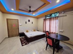 a room with a bed and a table and a window at Nmck Homestay in Guwahati