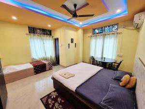 a bedroom with two beds and a ceiling with blue lights at Nmck Homestay in Guwahati