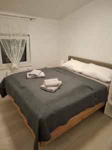 a large bed with two towels on top of it at Apartmani Pavic in Kustići
