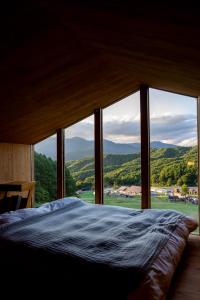 a bed in a room with a large window at Earthboat Minakami Hodaigi in Minakami