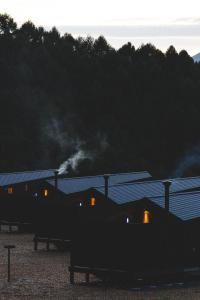 a train traveling past a building with smoke at Earthboat Minakami Hodaigi in Minakami