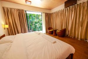 a bedroom with a bed and a large window at Dilco Nature Resort - BERAGALA in Dambawelagama