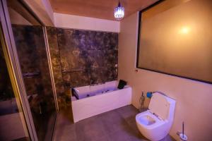 a bathroom with a toilet and a shower at Dilco Nature Resort - BERAGALA in Dambawelagama +33 photos