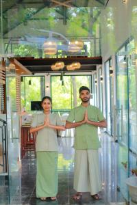 a man and woman standing in a room with their hands at Dilco Nature Resort - BERAGALA in Dambawelagama