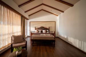 a bedroom with a bed and a chair in a room at VIHARA By CMK in Cochin