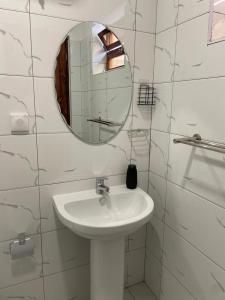 a white bathroom with a sink and a mirror at Apartamentos Andrade in Espargos +5 photos