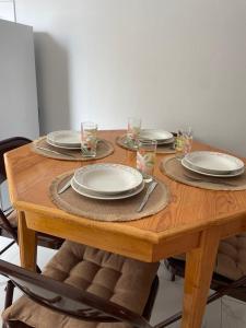 a wooden table with plates and glasses on it at Apartamentos Andrade in Espargos