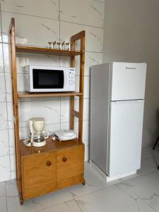 a microwave on a shelf next to a refrigerator at Apartamentos Andrade in Espargos