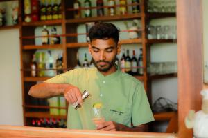 a man standing behind a counter with a drink at Dilco Nature Resort - BERAGALA in Dambawelagama