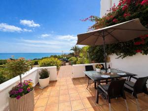 a patio with an umbrella and a table and chairs at Luxury House - Montesol ALBERT VILLAS in Alcossebre