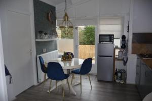 a kitchen with a white table and blue chairs at Villa Rosa in Andijk