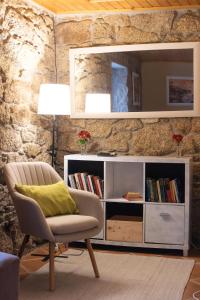 a living room with a chair and a book shelf at A Banda do Río in Vilagarcia de Arousa