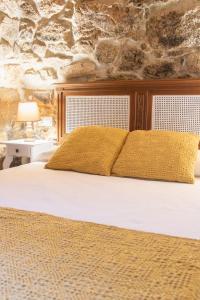 a bedroom with a white bed with yellow pillows at A Banda do Río in Vilagarcia de Arousa