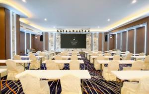 a conference room with tables and chairs and a screen at Enrich Grand Hotel in Bangkok +75 photos