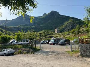 a parking lot with cars parked in front of mountains at Camping Koman in Koman