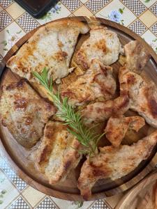 a pizza on a wooden plate on a table at Camping Koman in Koman