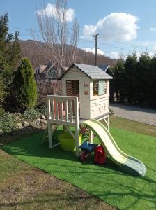 a playground with a slide and a house at CHALUPA OSTRAVICE in Ostravice