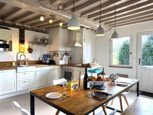 a kitchen with a wooden table and a dining room at Maison XVIIIe avec vue panoramique exceptionnelle - 12 pers au coeur du Pays d'Auge in Le Renouard +20 photos