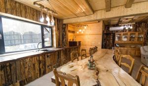 a dining room with a large wooden table and chairs at Casa Hiru in Nucşoara