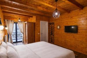 a bedroom with a bed and a flat screen tv at Casa Hiru in Nucşoara +5 photos