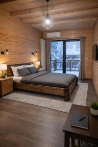 a bedroom with a bed and a large window at Casa Hiru in Nucşoara