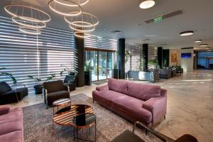 a lobby with a couch and chairs in a building at Best Western PLUS Premium Inn in Sunny Beach