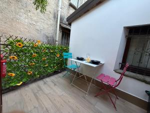 a table and chairs next to a fence with flowers at Casa vacanze by Michele in Verbania