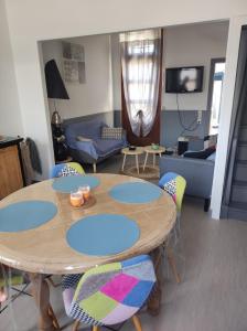 a living room with a wooden table and chairs at L Atelier de papa in Dargnies