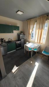 a kitchen with green cabinets and a table and chairs at YoniHarmony - 2 parking places in Sosnowiec