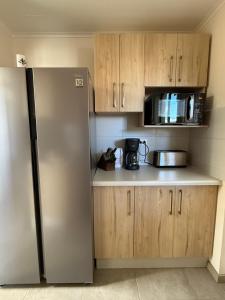 a kitchen with a stainless steel refrigerator and a microwave at Cómoda casa con 3 habitaciones de lujo en Talca in Talca