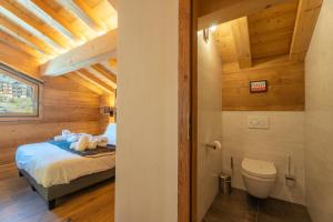 a bedroom with a bed and a toilet in a room at Hameau des clos Téléporté in Les Gets +54 photos