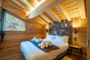 a bedroom with a bed with stuffed animals on it at Hameau des clos Téléporté in Les Gets