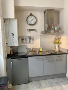 a kitchen with a sink and a clock on the wall at Albi-Suite in Albi +7 photos