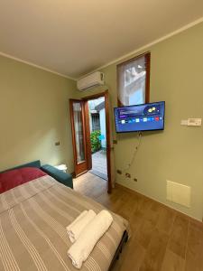 a bedroom with a bed and a flat screen tv on the wall at Casa vacanze by Michele in Verbania