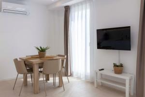 a dining room with a table and chairs and a tv at Apartamentos Armonia Peñíscola in Peniscola