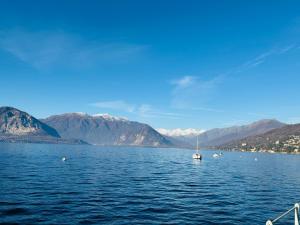 a sailboat in a large body of water with mountains at Casa vacanze by Michele in Verbania +4 photos