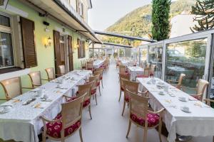 a row of tables and chairs in a restaurant at Albergo al Cervo - Gasthof zum Hirschen in Lagundo