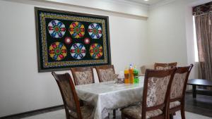 a dining room with a table and a picture on the wall at Hepci Hotel Istaravshan in Ŭroteppa