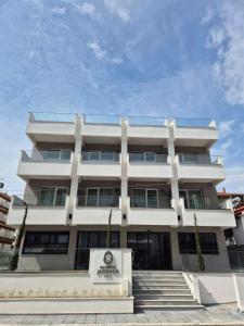 a white building with stairs in front of it at Olympus Jankaea in Paralia Katerinis