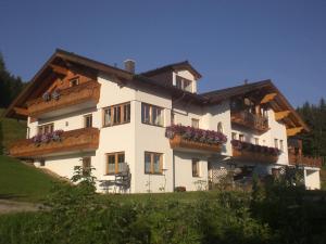 een groot wit huis met balkons op een heuvel bij Appartement Hutegger in Schladming