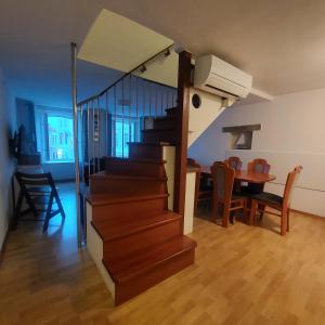 a room with a staircase and a dining room with a table at Ellipse apartment in Piran