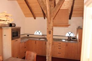 a kitchen with wooden cabinets and a wooden pole at Scholtenhoes in Hezingen +28 photos