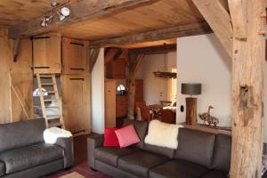 a living room with a couch and a ladder at Scholtenhoes in Hezingen
