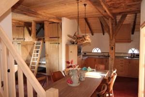 a kitchen and dining room with a wooden table at Scholtenhoes in Hezingen