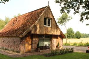 an old brick barn with a roof at Scholtenhoes in Hezingen