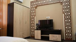 a bedroom with a sliding door with a tv on it at Hepci Hotel Istaravshan in Ŭroteppa