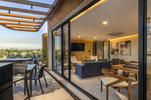 an open living room with glass doors and a couch and tables at WELL Residences - By AVA Rentals in Asunción