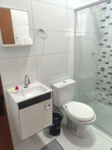 a bathroom with a toilet and a sink and a shower at Casa de Praia do Adriano in Itapoa +20 photos
